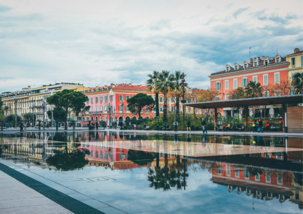 Vue sur la Promenade des Anglais et ses bâtiments colorés reflétés dans l’eau. Bordée de palmiers et longeant la baie, cette promenade mythique incarne l’art de vivre niçois, entre mer, espaces piétons et façades emblématiques de la Côte d’Azur.